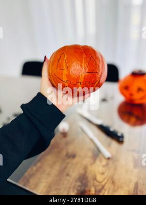 Abgeschnittene Aufnahme von Frauen, die große Orange schnitzen Stockfoto