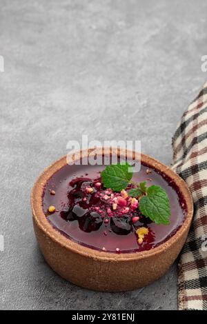 Kleine Kuchen mit Johannisbeere auf grauem Hintergrund Stockfoto