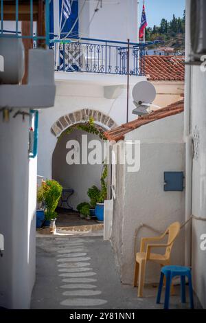 Wunderschöne weiß getünchte Wände mit blau lackierten Rollläden und Haustüren in engen Dorfstraßen auf der griechischen Insel Poros Stockfoto