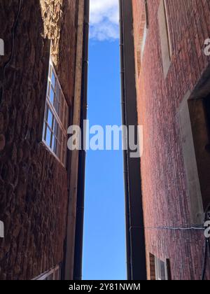 Ich schaue zwischen zwei Gebäuden auf den blauen Himmel Stockfoto