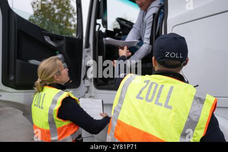 Chemnitz, Deutschland. Oktober 2024. Zollbeamte kontrollieren im Rahmen eines bundesweiten Such- und Kontrolltages einen Lkw auf der Raststätte Auerswalder Blick auf der Autobahn A4 bei Chemnitz. Am Tag der Suche waren Kontrollpunkte in den jeweiligen Zuständigkeitsbereichen der Polizeistationen der Chemnitzer Polizeidienststelle und auf der A4 besetzt. Gleichzeitig wurden mobile Kontrollen durchgeführt. Unterstützung leisteten Bundespolizisten und Zollbeamte. Quelle: Hendrik Schmidt/dpa/Alamy Live News Stockfoto