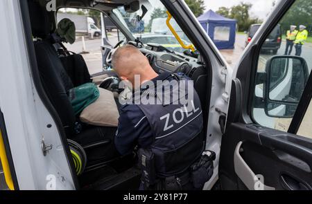 Chemnitz, Deutschland. Oktober 2024. Ein Zollbeamter durchsucht im Rahmen eines bundesweiten Such- und Kontrolltages einen Lieferwagen auf der Raststätte Auerswalder Blick an der Autobahn 4 bei Chemnitz. Am Tag der Suche waren Kontrollpunkte in den jeweiligen Zuständigkeitsbereichen der Polizeistationen der Chemnitzer Polizeidienststelle und auf der A4 besetzt. Gleichzeitig wurden mobile Kontrollen durchgeführt. Unterstützung leisteten Bundespolizisten und Zollbeamte. Quelle: Hendrik Schmidt/dpa/Alamy Live News Stockfoto