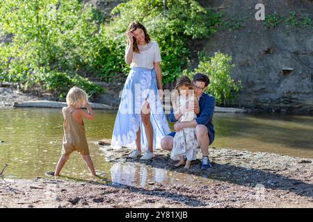 Vierköpfige Familie verbringt Zeit zusammen an einem sonnigen Tag am Ufer Stockfoto