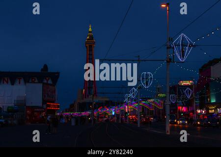 Während die leuchtenden Lichter der Blackpool Illuminations am Nachthimmel funkeln, steht der berühmte Blackpool Tower stolz im Hintergrund. Stockfoto