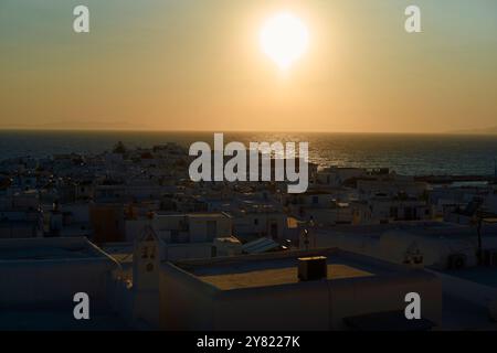 Sonnenuntergang über den weiß getünchten Gebäuden einer griechischen Insel mit Blick auf das Meer. Stockfoto