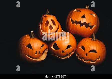 Weihnachtskarte mit Halloween-Kürbissen mit geschnitzten Gesichtern, um die Herbstferien zu dekorieren Stockfoto