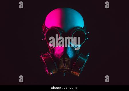 Menschlicher Schädel in Steampunk-Gläsern und Gasmaske mit rosa und blauem Licht auf schwarzem Hintergrund Stockfoto