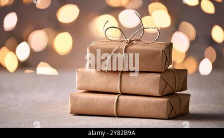 Weihnachtsgeschenke in braunem Papier gestapelt auf Schnee, gebunden mit rustikaler Schnur, minimalistische festliche Feiertagsszene, Winter Bokeh Glühlicht Hintergrund Stockfoto