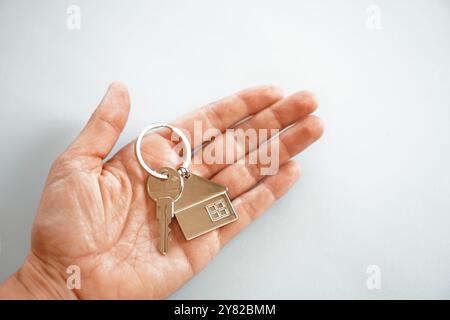 Offene Hand mit Schlüssel und Schlüsselring eines Hauses Stockfoto