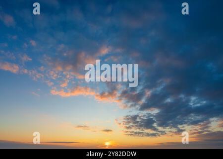 Leuchtender echter Himmel bei Sonnenuntergang Textur Hintergrund Overlay. Dramatische rote, orange und lila Wolken und untergehende Sonne. Hochauflösende Fotografie perfekt für Stockfoto