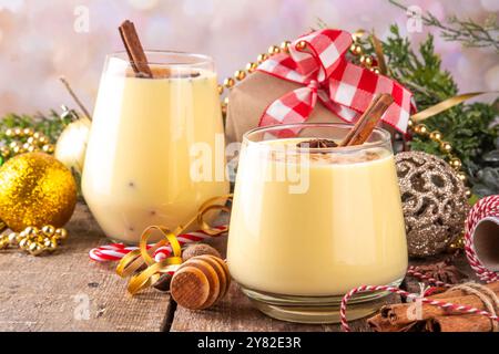 Weihnachtsgetränk mit Zimtstangen und Anissternen, zwei Gläser süßen klassischen Eierlikör-Cocktail an Weihnachten, Silvester dekoriert Hintergrund mit fi Stockfoto