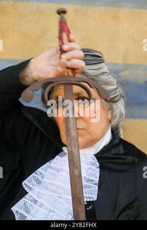 Hochrangige Richterin in einem richterlichen Gewand, die ein Schwert mit einem entschlossenen Ausdruck hält und die Macht des Rechts, der Gerechtigkeit und des Kampfes gegen Inj symbolisiert Stockfoto