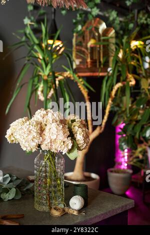 Vertikales Hintergrundbild einer detaillierten Dekorationskomposition mit Blumen und Plänen in mystischer Umgebung bei schwachem Licht Stockfoto