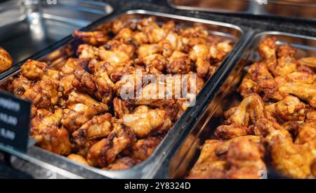 Frisch gebratene Hähnchenflügel und -Beine. Frisch gebratene Hähnchenflügel und -Beine. Lese zum Essen, lecker und heiß. Haagse Market in den Haag, Niederlande. niederlande den haag B97A6943 Stockfoto