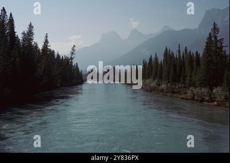 Bow River mit Bergen in rauchiger Atmosphäre bei Waldbränden, Canmore, Alberta, Kanadische Rocky Mountains Stockfoto