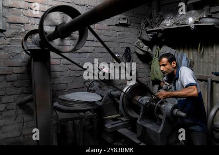 Dhaka, Dhaka, Bangladesch. Oktober 2024. In Kamrangirchar in Dhaka arbeiten Aluminiumfabriken unter gefährlichen Bedingungen. Arbeiter ohne Schutzausrüstung sind mit schädlichem Aluminiumstaub beschichtet, wenn sie schwere Maschinen in einer engen, schwach beleuchteten Umgebung handhaben. Wenn sie minimalem Licht von oben ausgesetzt sind, stehen sie neben gesundheitlichen Problemen vor schweren Sehstörungen. (Kreditbild: © Joy Saha/ZUMA Press Wire) NUR REDAKTIONELLE VERWENDUNG! Nicht für kommerzielle ZWECKE! Stockfoto