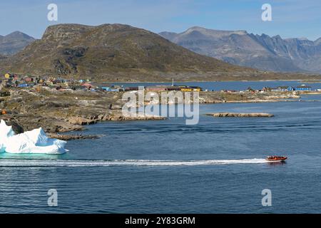 Nanortalik, Grönland - 27. August 2024: Motorboot, das Touristen auf eine Besichtigungstour an einem Eisberg in der Nähe der abgelegenen Stadt Nanortalik führt Stockfoto