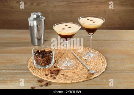 Gläser mit frischem Kaffee Cocktail, Shaker, Bohnen in der Schüssel und Mixlöffel auf Holztisch Stockfoto