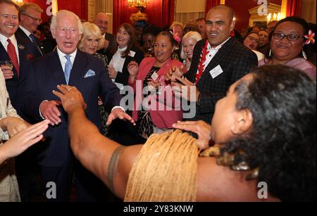 König Karl III. Reagiert, als der ehemalige samoanische Rugbyspieler Freddie Tuilagi während eines Empfangs im St. James's Palace in London tanzt, um die Commonwealth Diaspora zu feiern, bevor die Regierungschefs des Commonwealth in Samoa zusammentreffen. Bilddatum: Mittwoch, 2. Oktober 2024. Stockfoto