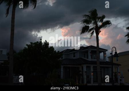 Horizontaler Blick auf Palmen in Richtung St. Pete Beach, FL in Richtung Golf von Mexiko. Nahe Sonnenuntergang am späten Nachmittag. Goldene bunte Wolken Stockfoto