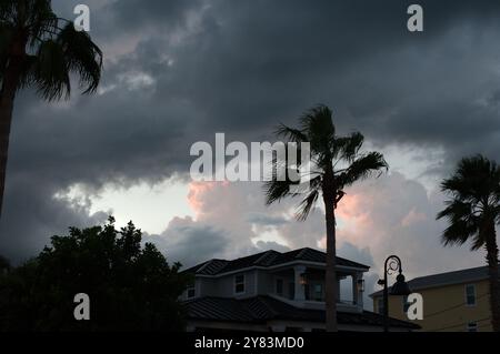 Horizontaler Blick auf Palmen in Richtung St. Pete Beach, FL in Richtung Golf von Mexiko. Nahe Sonnenuntergang am späten Nachmittag. Goldene bunte Wolken Stockfoto