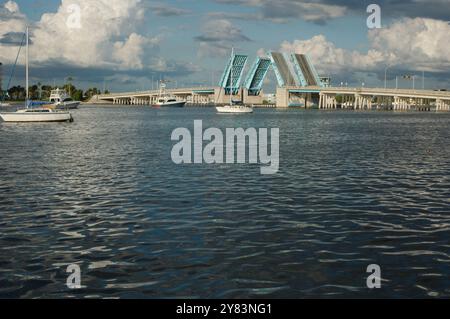 Blick von der Intercoastal in Richtung blau geöffneter Corey Causeway Zugbrücke. Zwei Segelboote in der Mitte und andere Boote, die unter der Brücke fahren. Geschwollenes Stockfoto