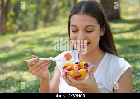 Eine junge Frau isst einen Obstsalat im Stadtpark Stockfoto