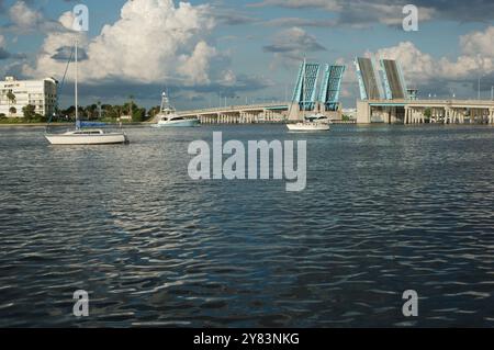 Blick von der Intercoastal in Richtung blau geöffneter Corey Causeway Zugbrücke. Zwei Segelboote in der Mitte und andere Boote, die unter der Brücke fahren. Geschwollenes Stockfoto