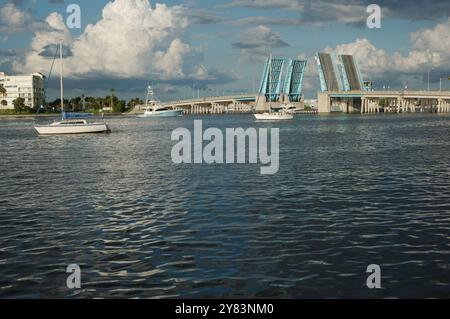 Blick von der Intercoastal in Richtung blau geöffneter Corey Causeway Zugbrücke. Zwei Segelboote in der Mitte und andere Boote, die unter der Brücke fahren. Geschwollenes Stockfoto