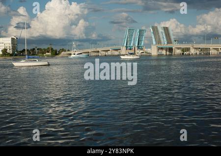 Blick von der Intercoastal in Richtung blau geöffneter Corey Causeway Zugbrücke. Zwei Segelboote in der Mitte und andere Boote, die unter der Brücke fahren. Geschwollenes Stockfoto