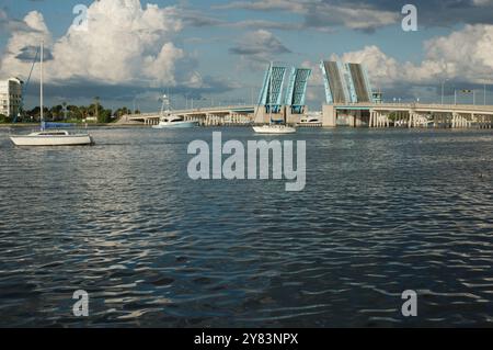 Blick von der Intercoastal in Richtung blau geöffneter Corey Causeway Zugbrücke. Zwei Segelboote in der Mitte und andere Boote, die unter der Brücke fahren. Geschwollenes Stockfoto