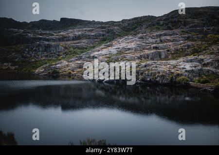 Ein Panoramablick auf die Berge und den See in Serra da Estrela, Portugal, bei regnerischem Wetter erfasst, wodurch eine ruhige und mystische Landschaft entsteht. Stockfoto