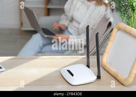 Moderner wlan-Router mit Rahmen auf Regal im Zimmer, Nahaufnahme Stockfoto