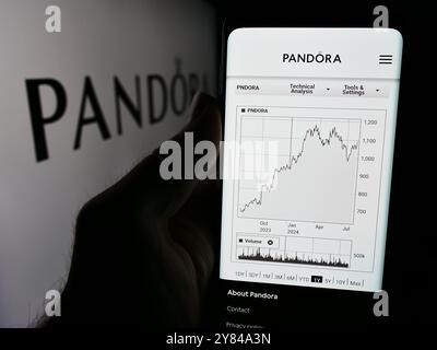 Deutschland. September 2024. In dieser Fotoabbildung hält eine Person ein Handy mit der Website des dänischen Schmuckunternehmens Pandora vor dem Firmenlogo. (Credit Image: © Timon Schneider/SOPA Images via ZUMA Press Wire) NUR REDAKTIONELLE VERWENDUNG! Nicht für kommerzielle ZWECKE! Stockfoto