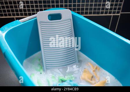 Ein graues Waschbrett. Die traditionelle Methode des Händewaschens ist effektiv, um Schmutz und Flecken von der Kleidung zu entfernen, da die Schrubbung hilft, Schmutz zu entfernen und sicherzustellen, dass das Gewebe gründlich gereinigt wird. Stockfoto