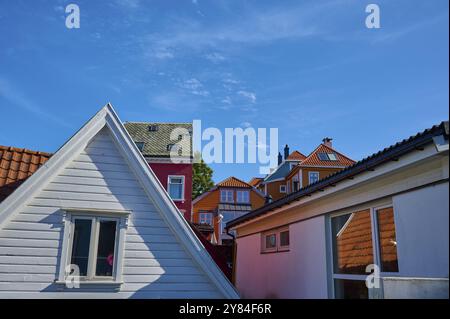 Farbenfrohe Häuser mit roten und weißen Dächern und Fassaden unter blauem Himmel mit weichen Wolken, Bergen, Vestland, Norwegen, Europa Stockfoto