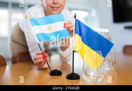 Koordinator des Büros, der die Flaggen der Ukraine und Argentiniens auf den Verhandlungstisch setzt Stockfoto