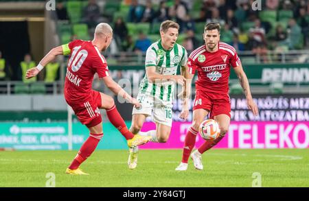 Budapest, Ungarn – 9. Oktober 2022. Ferencvaros Mittelfeldspieler Kristoffer Zachariassen gegen Debrecen-Spieler Balazs Dzsudzsak und Dusan Lagator Stockfoto