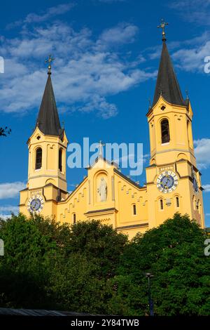 Marienkirche, die sich über grünen Bäumen erhebt, in Bruneck Stockfoto