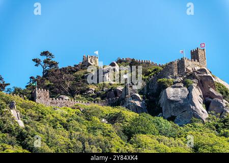 SINTRA, Portugal – die maurische Burg (Castelo dos Mouros) steht auf einem Hügel oberhalb der Stadt Sintra. Diese mittelalterliche Festung mit ihren Steinmauern, die sich entlang des Berges schlängeln, bietet eine dramatische Silhouette am Himmel und bietet einen beeindruckenden Blick auf die umliegende Landschaft. Stockfoto