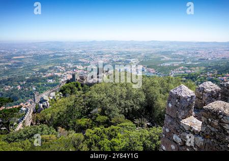 SINTRA, Portugal – Ein fantastischer Panoramablick von der Spitze der Maurischen Burg (Castelo dos Mouros) in Sintra. Die mittelalterliche Festung hoch oben in den Sintra Bergen bietet atemberaubende Ausblicke auf die umliegende Landschaft, einschließlich Blicke auf andere historische Sehenswürdigkeiten und den fernen Atlantik. Stockfoto