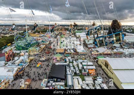 Flug durch den Münchner Himmel, vom Kettenflieger Bayern Tower bietet sich ein toller Blick auf das Oktoberfest, München, Oktober 2024 Deutschland, München, Oktober 2024, Wiesnbesucher genießen den Flug durch den Münchner Himmel, in 90 Meter Höhe haben sie einen wunderbaren Blick über das Oktoberfest, Kettenflieger Bayern Tower, 90 Meter hohes Kettenkarussell, Theresienwiese, Fahrgeschäft gehört Schausteller Egon Kaiser, Mittwochabend, Himmel bewölkt, Wiesnwetter, bayerisch, Volksfest, Herbst, Bayern, *** Flug durch den Münchner Himmel, vom Kettenflieger Bayern Turm hat man eine tolle Aussicht Stockfoto