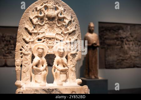 WASHINGTON DC, Vereinigte Staaten – Marmorstele, die Maitreya, Buddha der Zukunft, neben den Buddhas der Vergangenheit und Gegenwart darstellt, die 565 n. Chr. in Quyang, Provinz Hebei, China, geschaffen wurde. Diese bedeutende buddhistische Skulptur, die in der Freer Gallery of Art ausgestellt wird, veranschaulicht religiöse Kunst der Nördlichen Qi-Dynastie und raffinierte Steinschnitzertechniken. Stockfoto