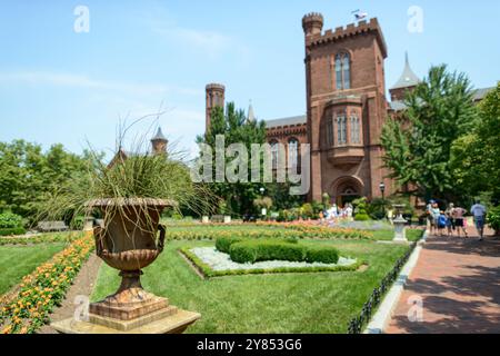 WASHINGTON, D.C. – das Smithsonian Institution Building, allgemein bekannt als Smithsonian Castle, vom Enid A. Haupt Garden in der National Mall aus gesehen. Das 1855 fertiggestellte Gebäude aus rotem Sandstein beherbergt den Verwaltungssitz der Smithsonian Institution und zeigt die Dauerausstellung Smithsonian Institution: America's Treasure Chest. Das vom Architekten James Renwick Jr. im Stil des Norman Revival entworfene Gebäude dient als zentrales Wahrzeichen des weltweit größten Museums- und Forschungskomplexes. Der 1987 gegründete Enid A. Haupt Garden ist eine 4,2 Hektar große Dachterrasse Stockfoto
