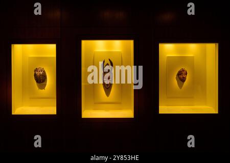 Afrikanische Masken Smithsonian National Museum of African Art Washington DC | WASHINGTON D.C., Vereinigte Staaten — drei geschnitzte afrikanische Masken, beleuchtet in einzelnen Wandbehältern, sind Teil der permanenten Sammlung des Smithsonian National Museum of African Art Die gehörnte Maske im Zentrum und ihre Begleiter repräsentieren unterschiedliche regionale Maskierungstraditionen aus Westafrika. Das Museum, das 1987 in der National Mall eröffnet wurde, beherbergt rund 12.000 Objekte von alter bis zeitgenössischer afrikanischer Kunst. Stockfoto