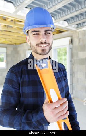 Porträt eines glücklichen Arbeiters mit Wasserwaage Stockfoto