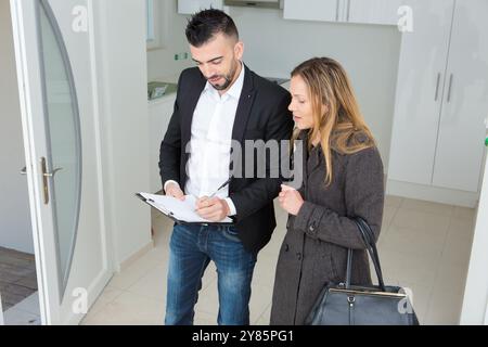 Immobilienmakler zeigt Wohnung einer jungen Frau Stockfoto