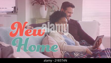 Bild des neuen Home-Textes über verschiedenen Paaren mit Tablet auf Sofa Stockfoto