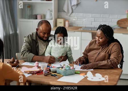 Familie genießt gute Zeit zusammen sitzen am Tisch und machen Kunst und Kunsthandwerk Aktivität Eltern und Kinder arbeiten zusammen und schaffen bunte Kunstwerke Stockfoto