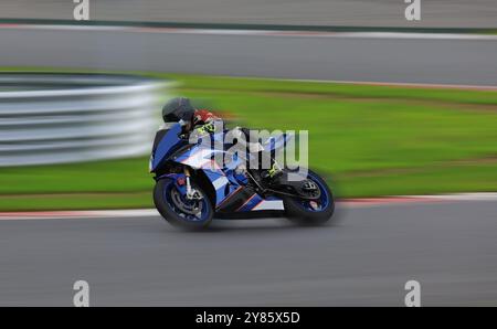 Rennradfahrer lehnen sich mit hoher Geschwindigkeit in eine schnelle Kurve auf der Rennstrecke Stockfoto